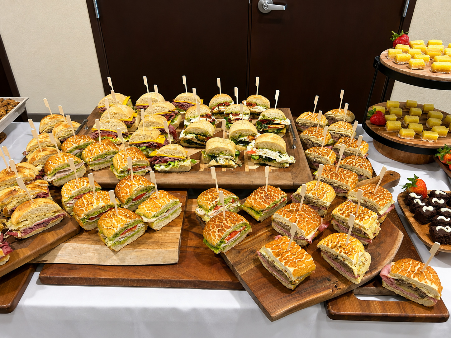 Wooden boards of gourmet sandwiches cut and skewered for a catered event